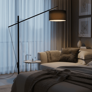 A stylish black floor lamp beside a cozy sofa, illuminating a modern living space with soft light.