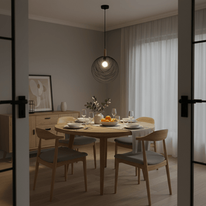 Stylish black pendant light hanging over a wooden dining table set with plates and glasses.