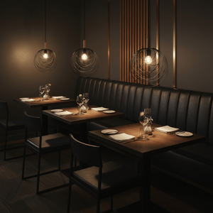 Stylish black pendant lights hang over wooden dining tables in a modern restaurant setting.