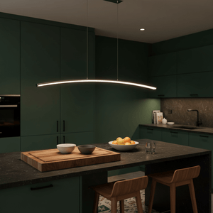 Sleek Maybe Someday Bow LED Pendant light hanging over a kitchen island with bowls and fruits.