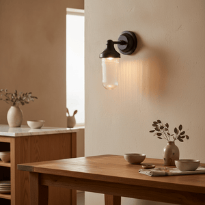 Elegant Fabio Hanging Lamp in Matt Black mounted on a textured wall, illuminating a wooden table with decor.