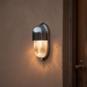 Shetland Outdoor Wall Light mounted on a textured wall, illuminating the area with a warm glow.