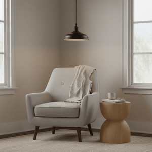 Ducasse Hanging Lamp in matt black above a cozy chair with a blanket and a wooden side table.