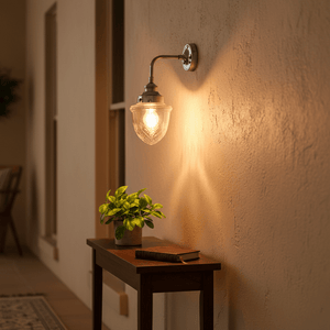 Antique silver wall lamp with cut glass design illuminating a cozy indoor space, complemented by a small plant and wooden