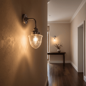 Antique silver wall lamp with cut glass design illuminating a hallway, enhancing the elegant decor.