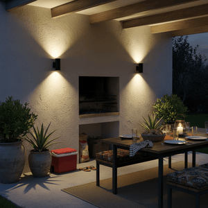Black outdoor wall light illuminating a patio area with a dining table and plants.