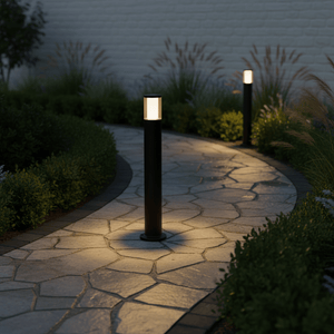 Two Carlo 800 LED bollards illuminate a winding stone pathway surrounded by lush greenery.