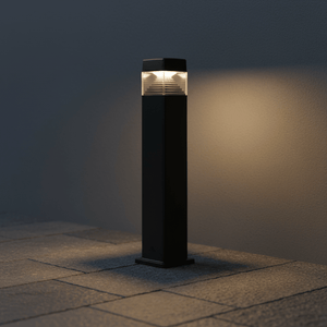Stylish LED bollard light illuminating a stone pathway, showcasing its sleek design and warm glow.