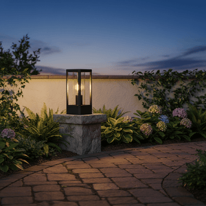 Bhok Ali Square Outdoor Post Top Light on a stone pillar, surrounded by lush greenery and flowers, at dusk.