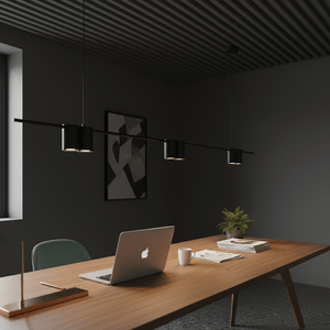 A sleek black linear pendant light with three visible fixtures above a modern wooden desk in a stylish office setting.