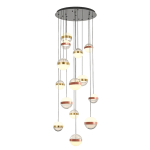 A cluster of spherical pendant lights in varying sizes, featuring gold, silver, and white finishes, suspended from a black ceiling mount.