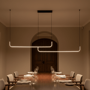 Stylish black LED pendant light illuminating a dining table set with glassware and plates.