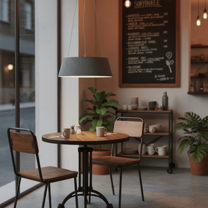 Grey metal and acrylic LED pendant light hanging above a wooden table in a cozy dining area.