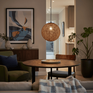 Twine Pendant light hanging above a round wooden dining table, creating a warm ambiance in a cozy living space.