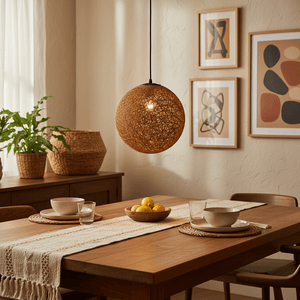 Natural twine pendant light hanging above a wooden dining table set with dishes and a bowl of lemons.