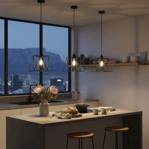 Three metal pendant lights with smoke glass shades hang over a kitchen island, creating a warm ambiance.