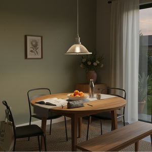 Metal pendant light in French white hanging above a wooden dining table with fruit and decor.