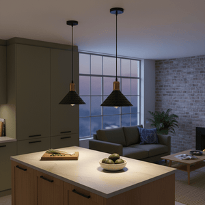 Two black iron pendant lights hang over a kitchen island with a bowl of avocados and a cutting board.