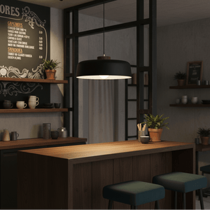Black metal pendant light hanging over a wooden bar with green stools, surrounded by shelves and decor.