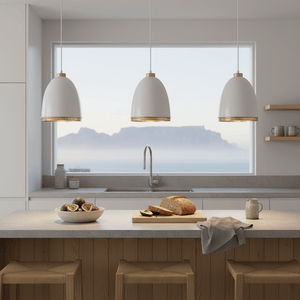 Three white iron pendant lights hang above a kitchen island with a scenic view.