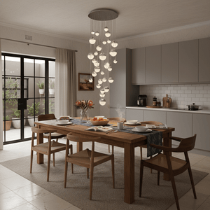 Stylish chandelier with multiple glass orbs hanging above a wooden dining table set with dishes and flowers.