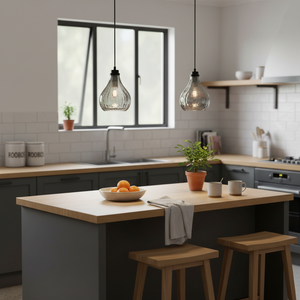 Stylish kitchen scene featuring two glass pendant lights above a wooden island with fruit and mugs.