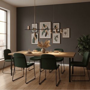 Black and gold pendant light above a wooden dining table with green chairs and decorative wall art.
