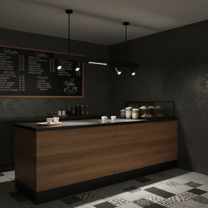 Black magnetic track lights illuminate a modern cafe counter with cups and pastries.
