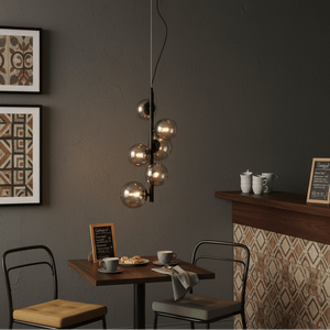 Nebula Metal Pendant with smoke glass shades illuminating a cozy dining setup with coffee and pastries.