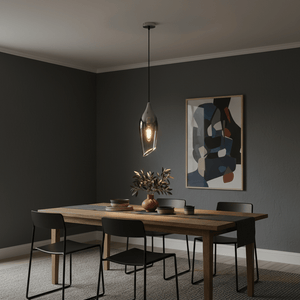 Satin nickel pendant light with smoke glass shade hanging over a wooden dining table, surrounded by black chairs.