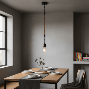 Metal pendant light with rope detail hanging over a dining table set with plates and a vase.