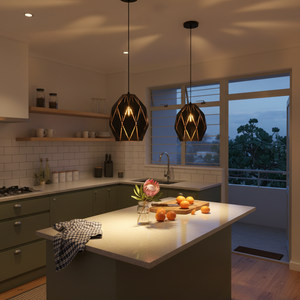 Two black metal pendant lights hanging over a kitchen island with fresh fruits and a floral arrangement.