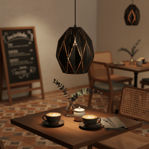 Stylish black metal pendant light illuminating a cozy café table with coffee cups and greenery.