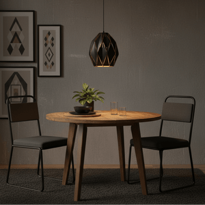 Black metal pendant light hanging above a wooden dining table with two chairs and decorative plant.