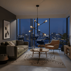 Stylish black and gold pendant light with adjustable arms hanging in a modern living room setting at night.