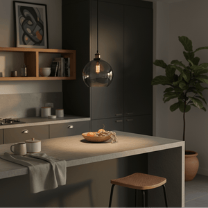Smoke-glass pendant light hanging above a kitchen island with a bowl of fruit and a cozy atmosphere.