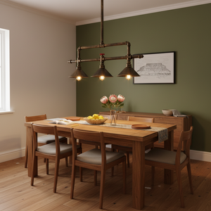 Three-light aluminium pendant light hanging above a wooden dining table with flowers and fruit.
