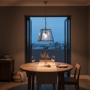 Stylish pendant light above a wooden dining table set for two, with city view in the background.