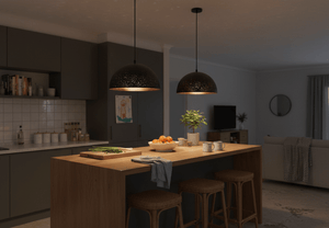 Black metal pendant light with starry cut-out shade hanging over a wooden kitchen island, creating a cozy ambiance.