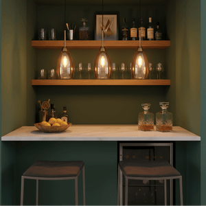 Three amber glass pendant lights hang above a marble countertop with a bowl of lemons and barware.