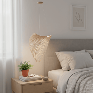 Elijah Natural LED Pendant light hanging above a bedside table with a plant and books.