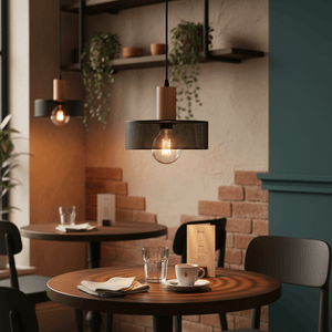 Enid Pendant Light in a cozy café setting, illuminating a wooden table with a coffee cup and glass.