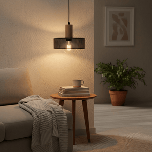 Enid Pendant Light hanging above a cozy sofa, illuminating a side table with books and a cup.