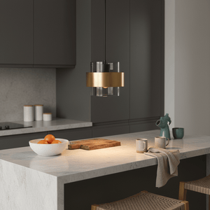Astrid Gold Pendant Light hanging above a kitchen island with a marble countertop, featuring decorative items.