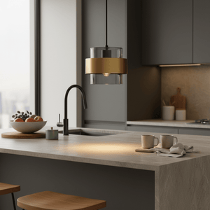 Astrid Gold Pendant Light hanging above a kitchen island with a bowl of fruit and coffee mugs on the counter.