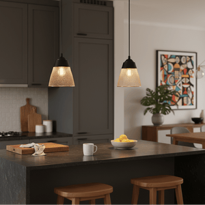 Two Billie black and gold pendant lights hanging over a modern kitchen island with a bowl of lemons and a coffee mug.