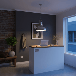 Satin Chrome Pendant light illuminating a modern reception area with a wooden counter and brick wall.