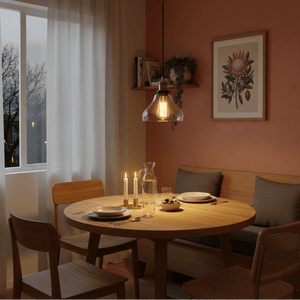 Antique brass pendant light illuminating a cozy dining area with a round wooden table, candles, and decor.