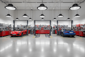 LED high bay lights illuminating a modern automotive workshop with red and blue cars.