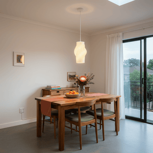 Dahlia pendant light hanging above a wooden dining table with a floral centerpiece and fruit bowl.